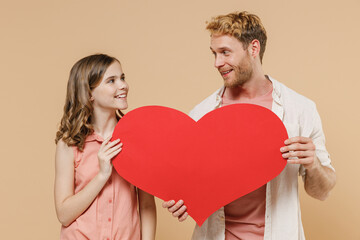 Young parent man with child teen girl in casual clothes Daddy kid daughter hold huge red heart mock up look to each other isolated on beige background studio portrait Father's Day Love family concept