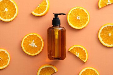 Amber glass pump bottle with natural shampoo with Vitaminc C and sliced orange top view.