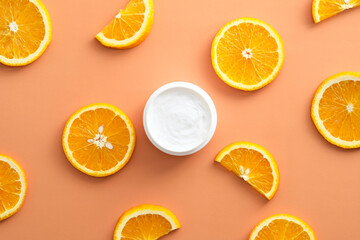 Natural Vitamin C moisturizer cream jar and sliced orange. Skincare concept. Flat lay, top view