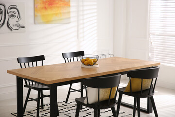 Stylish wooden dining table and chairs in room. Interior design