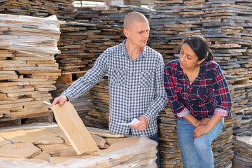 Manager and worker of the construction store keep records of natural stone tiles