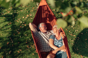 senior couple bonding on the hammock. free time together. positive retired people. - Powered by Adobe