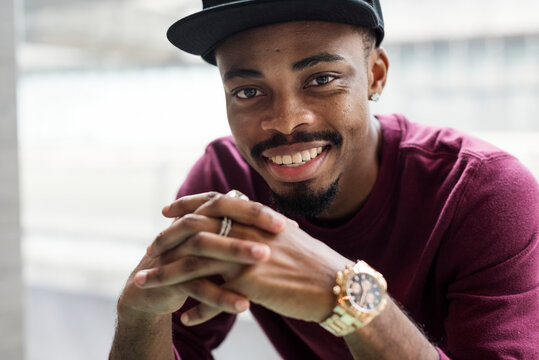 Young Man Smiling For A Portrait With Fingers Interlocked