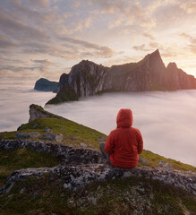 A tourist enjoying a view at the Mountain Hesten, Senja, Norway. Trekking in Norway, active life concept