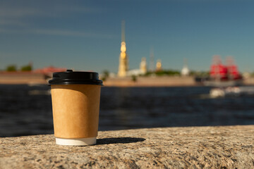 cup of natural coffee on embankment against background of Peter and Paul Fortress in St. Petersburg, Russia