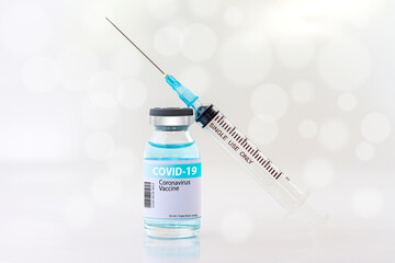 Vaccines against COVID-19. Photo of syringes and vaccine bottles on white bokeh background. Treatment for covid-19 coronavirus.
