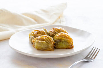 Mussels baklava Turkish pistachio baklava on a white background. Local name midye baklava