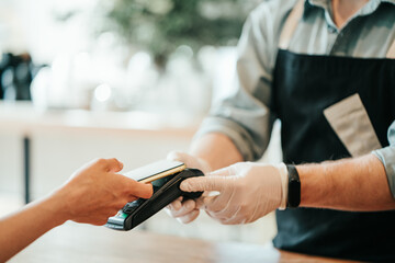 Mobile and safety wireless payment using cell phone and bank terminal. Coffee small business, close-up