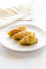 Turkish Dessert Sobiyet Baklava. Turkish pistachio baklava on a white background. Local name şöbiyet baklava