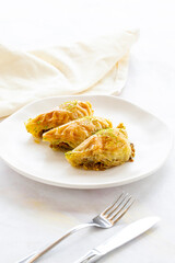 Turkish Dessert Sobiyet Baklava. Turkish pistachio baklava on a white background. Local name şöbiyet baklava