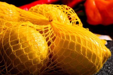 crisp close up of yellow lemon in net with red background