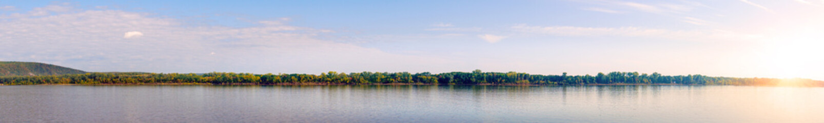 Fototapeta premium Panorama of a large river with a sandy Bank against a cloudy sky in the evening