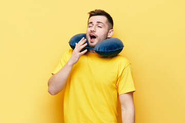 Tired young man yawning on yellow background