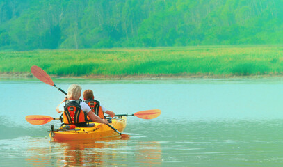 Kayaking and canoeing with family. The woman with a child on the lake and ride on kayak