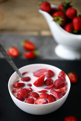 Strawberries with cream in a bowl. Summer milk dessert.