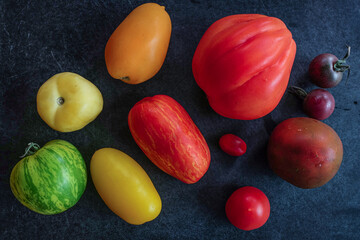 Different varieties of tomatoes against black background