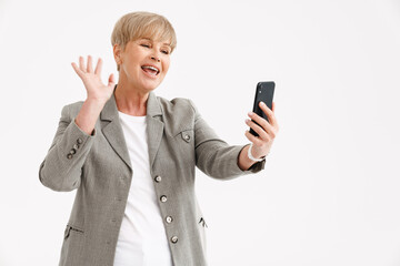 Fototapeta premium European mature woman in jacket gesturing while using mobile phone