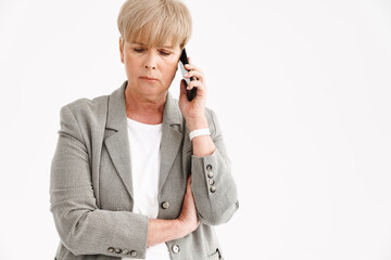 European mature woman in jacket talking on cellphone