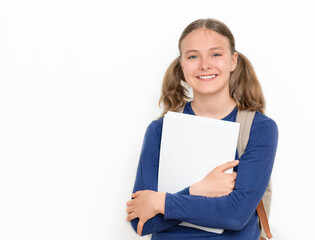 Education concept. Smiling teenager girl with copybooks and backpack on the gray background.