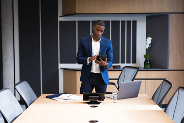 African american businessman using digital tablet in meeting room at office