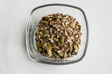 Mix of raw seeds-pumpkin seeds, sunflower seeds, line seeds and sesame seeds  in a glass bowl