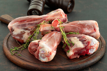 raw lamb shank on dark background