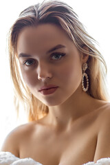 Fototapeta premium Portrait of a young girl standing on an isolated white background, with bare shoulders
