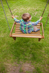 Child swinging on swing in the backyard