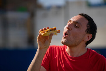 Very happy boy eating a hot dog