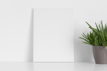 White canvas mockup with an aloe vera plant on the table.