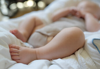 Fototapeta na wymiar close-up of 3 month old baby sleeping in bodysuit, focus on feet