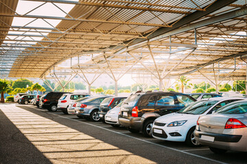 Cars On A Street Parking Lot Under Cover In Sunny Summer Day