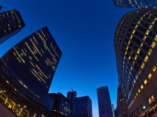 Canary Wharf skyscrapers, swirled and distorted by a fish-eye lens, appear to loom overhead against...