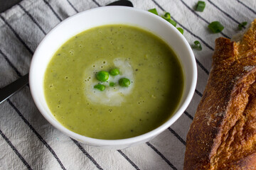 Close up photo of vegetarian soup in a bowl. Green peas creamy soup with onion. Healthy eating concept. 