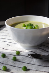 Green vegetable soup in a bowl. Top view photo of vegetarian meal. Homemade green peas creamy soup. Vegetarian menu ideas.  Eating fresh concept. 