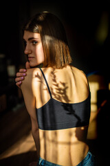 Beauty portrait of a back beautiful young girl with a shadow pattern on the face and body in the form of stripes. fashion, beauty. Female clavicle of green leaves. Close up.