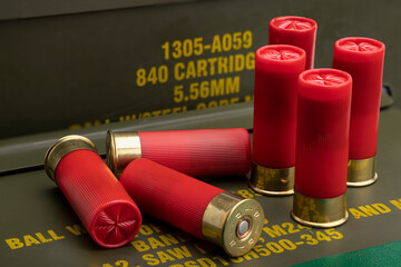 12 gauge bullet shotgun shell with green army ammo box background