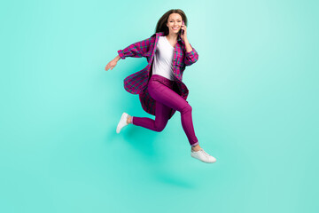 Fototapeta na wymiar Profile full length photo of cool young lady go talk telephone wear shirt trousers isolated on vivid teal color background