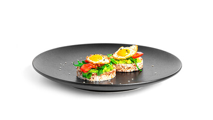Crispbread sandwich with guacamole, arugula, tomatoes and quail egg isolated on a white background....