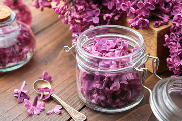 Obraz na płótnie Canvas Lilac flowers in a jar, oil or infusion bottle, bunch of Syringa flowers. The preparation of infusion, aromatic sugar or jam from Lilac flowers at home.