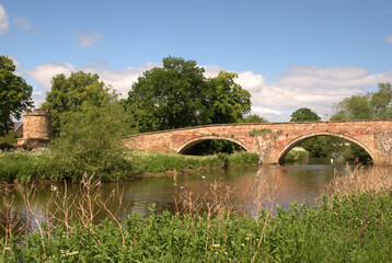 Fototapeta na wymiar stone bridge and tower on river Tyne Haddington in summer