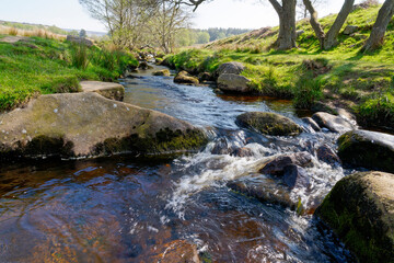 Fototapeta premium Burbage brook becomes a blur flowing over gritstone rocks