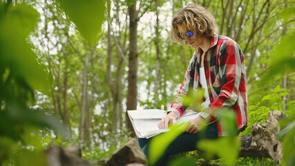 Man sits with compass and map. Orienteering.