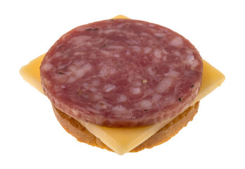 Obraz premium Side view of a slice of dry salami with gouda cheese on a round cracker.
