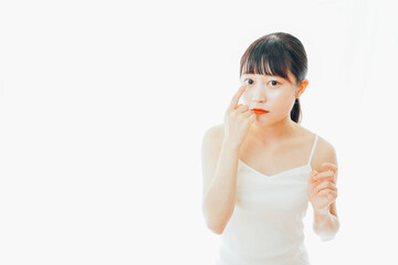 コンタクトレンズを装着する若い女性
