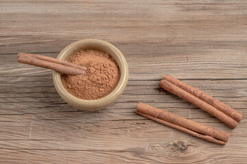 dried cinnamon sticks and powder on wooden table with copy space