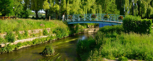 Panoramique La Loisance travers&eacute;e par un pont fleuri, coule dans un parc de verdure &agrave; Antrain (35560 Val-Couesnon), d&eacute;partement d'&Icirc;le-et-Vilaine en r&eacute;gion Bretagne, France