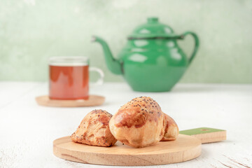 homemade pastry buns, glass of tea and teapot on the table