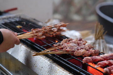 close up hand cooking barbecue on grill. soft focus