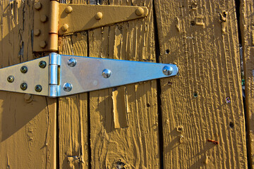 Paint on fence has dried , cracked and blistered in hot sunshine.